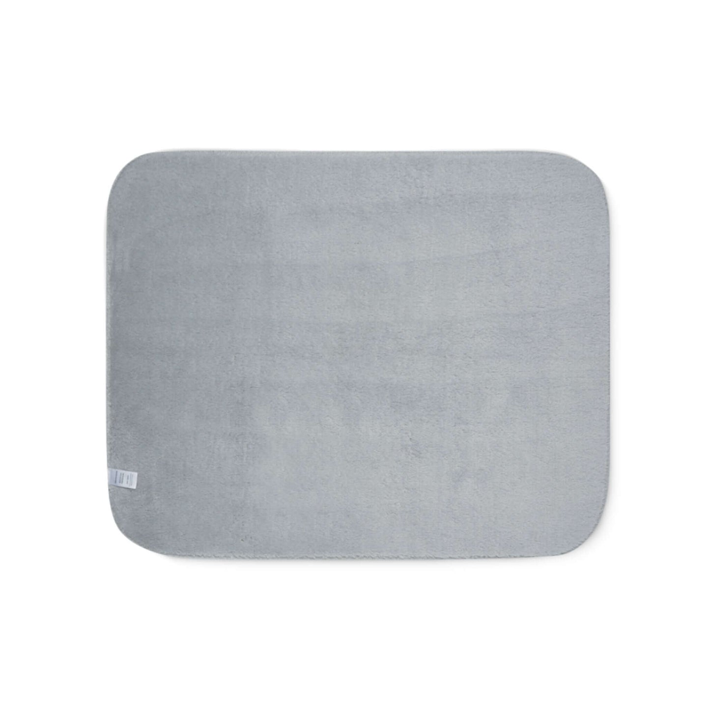 Soft grey sherpa blanket with rounded corners, perfect for cozying up by the fireplace.