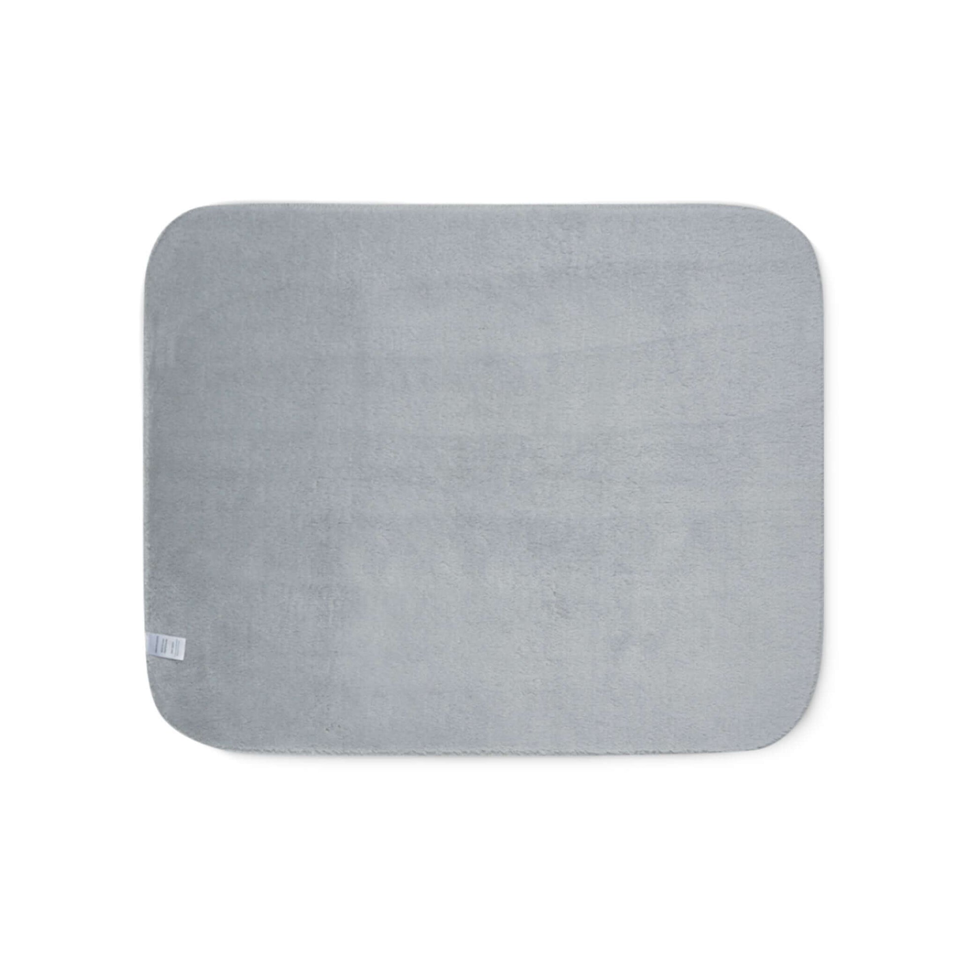 Soft grey sherpa blanket with rounded corners, perfect for cozying up by the fireplace.